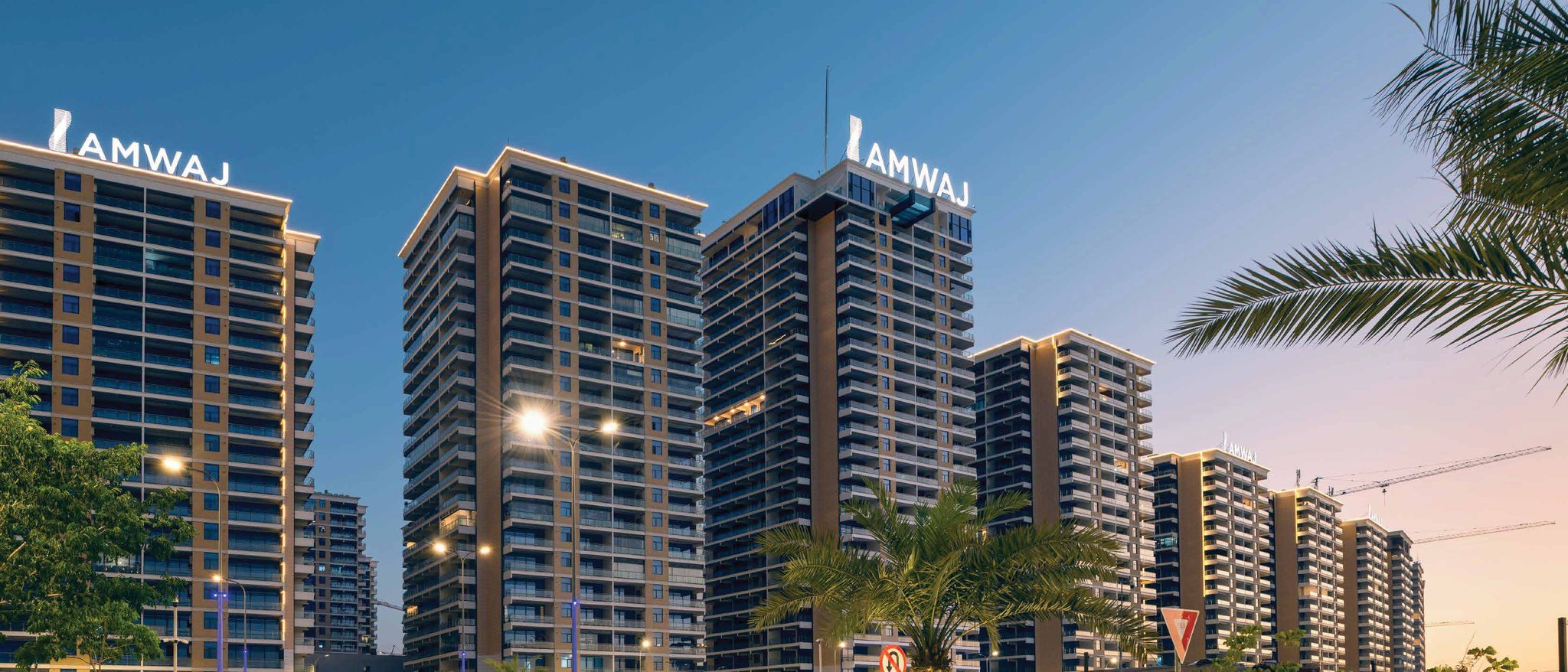 Iraq Gate – The Boulevard: residential towers at dusk with Amwaj rooftop signage